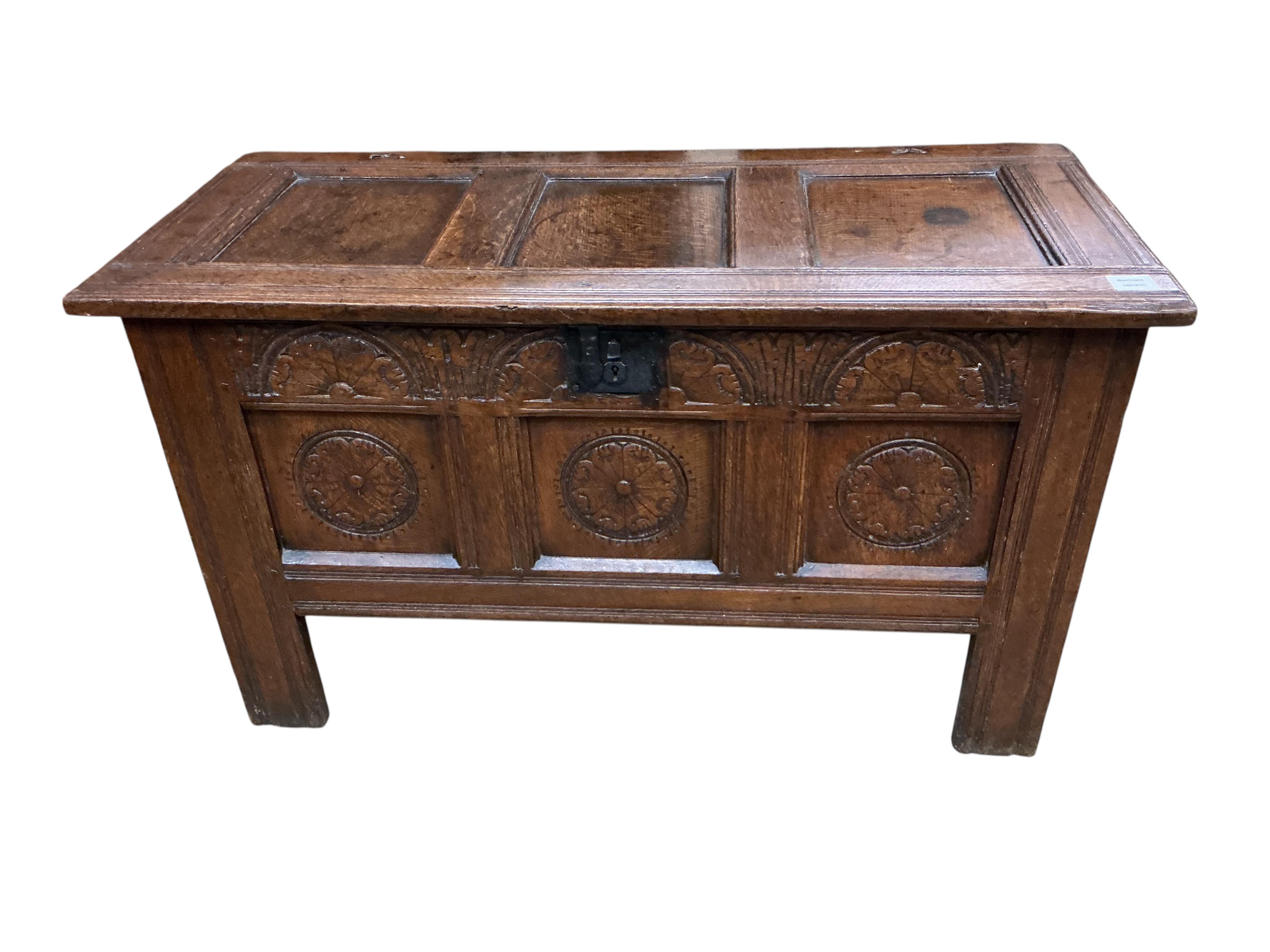 An oak coffer with three panels carved with roundels, width 106cm, depth 47cm, height 61cm